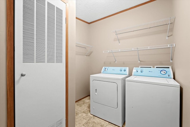 laundry area with washing machine and dryer and ornamental molding