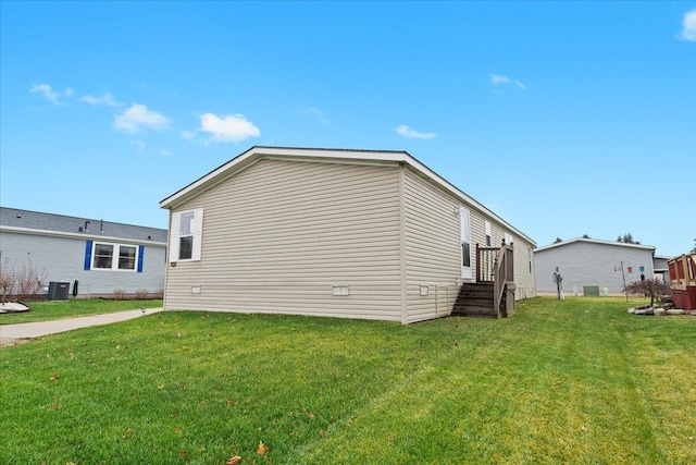 view of side of property with a yard and cooling unit