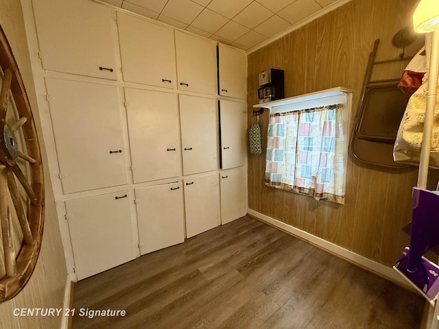 unfurnished bedroom with wood walls, a closet, and dark hardwood / wood-style flooring