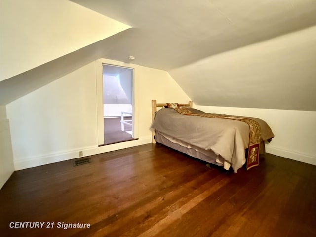 bedroom featuring dark hardwood / wood-style flooring and lofted ceiling