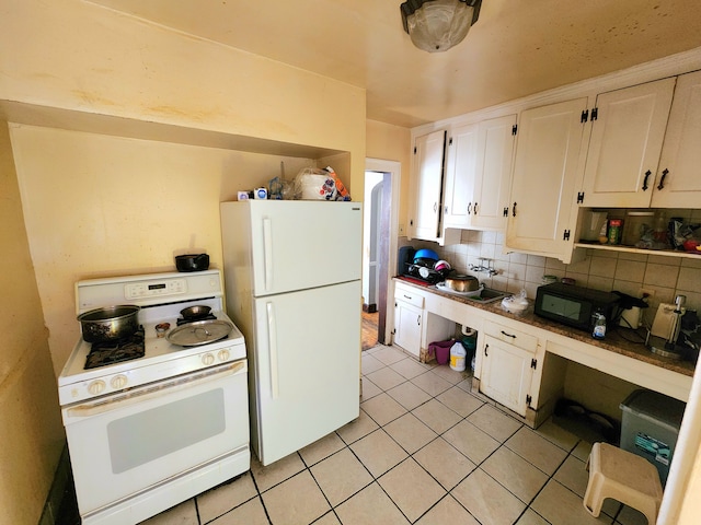 kitchen featuring white cabinetry, sink, light tile patterned floors, and white appliances