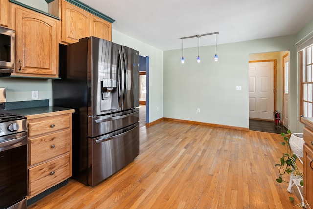 kitchen featuring stainless steel appliances, light wood-type flooring, pendant lighting, and plenty of natural light