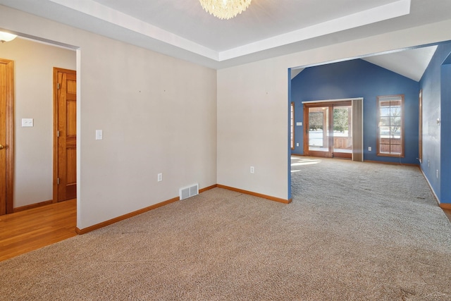 carpeted spare room with a notable chandelier