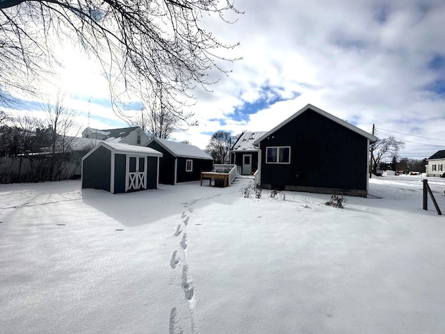 snow covered house with a storage unit