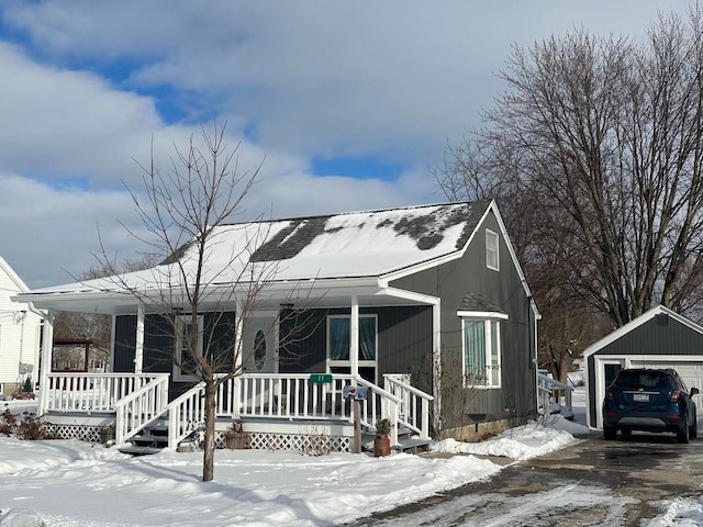 view of front of property with a garage, a porch, and an outdoor structure