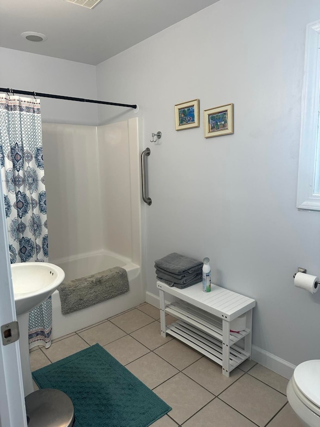 bathroom with toilet, tile patterned flooring, and shower / bath combination with curtain