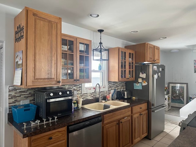 kitchen featuring stainless steel appliances, sink, light tile patterned flooring, tasteful backsplash, and pendant lighting