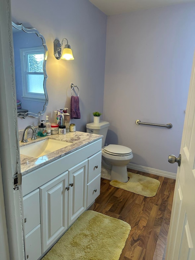 bathroom featuring hardwood / wood-style floors, vanity, and toilet