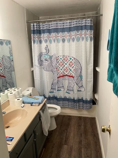 full bathroom featuring toilet, vanity, hardwood / wood-style floors, and shower / bath combination with curtain