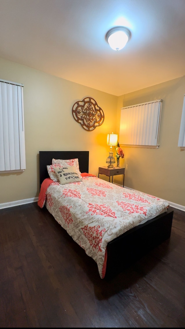 bedroom with dark hardwood / wood-style floors