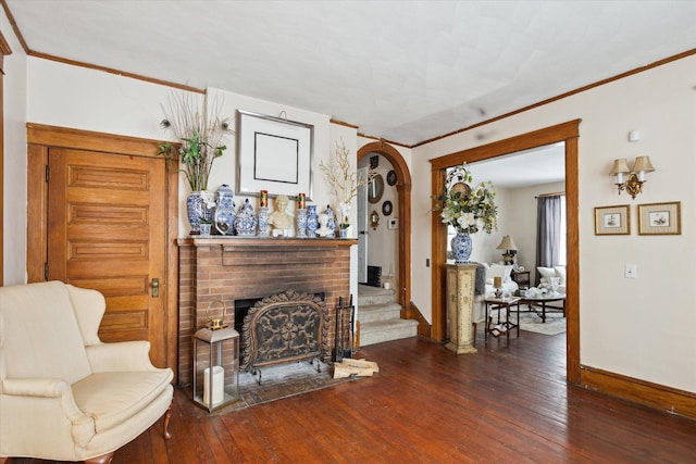 living area featuring dark wood-type flooring and a brick fireplace