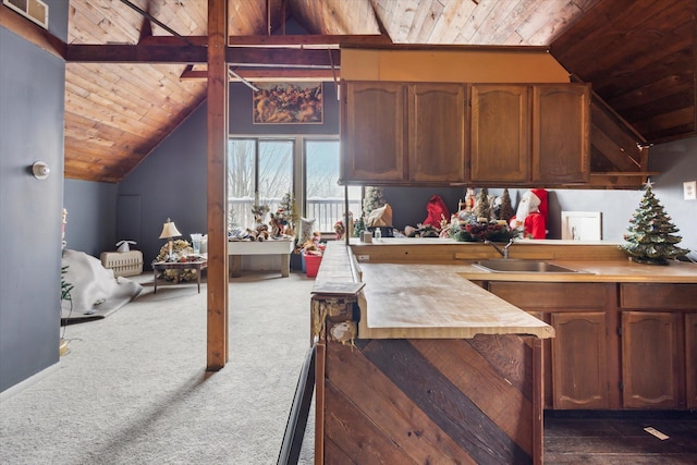 kitchen featuring dark colored carpet, sink, wooden counters, and vaulted ceiling