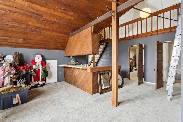 interior space with light carpet, vaulted ceiling with beams, kitchen peninsula, and wood ceiling