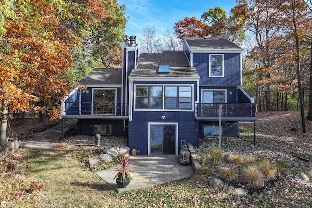 back of property featuring a deck and a patio area