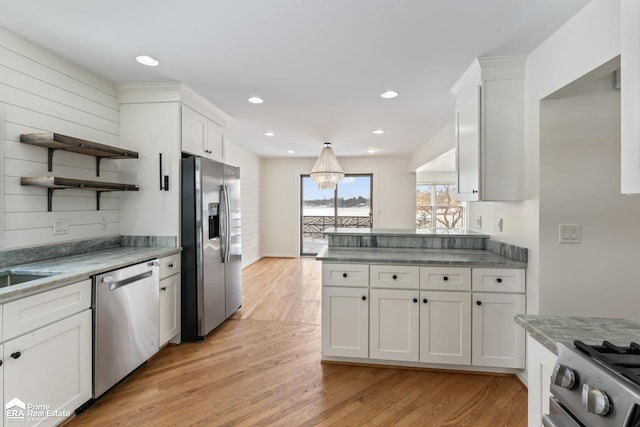 kitchen featuring stainless steel appliances, light hardwood / wood-style flooring, and white cabinetry