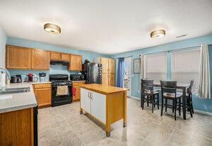 kitchen with a center island, fridge, sink, and black range with gas stovetop