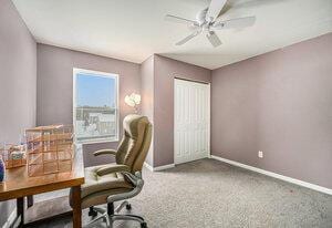 carpeted office space featuring ceiling fan