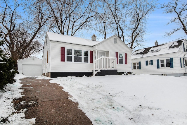 view of front of home with a garage and an outbuilding