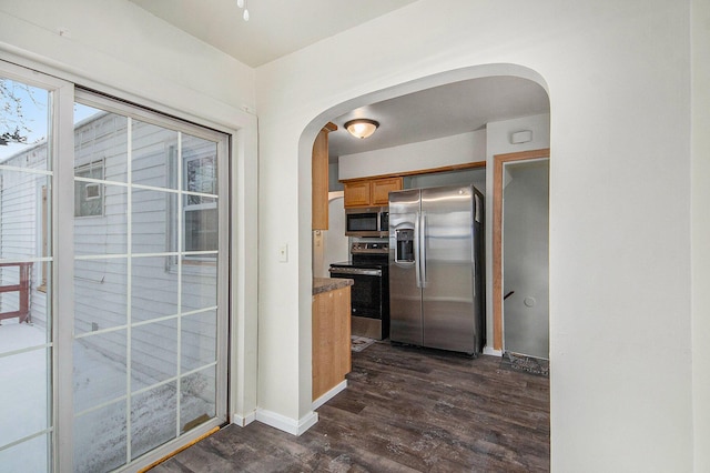 kitchen with appliances with stainless steel finishes and dark wood-type flooring