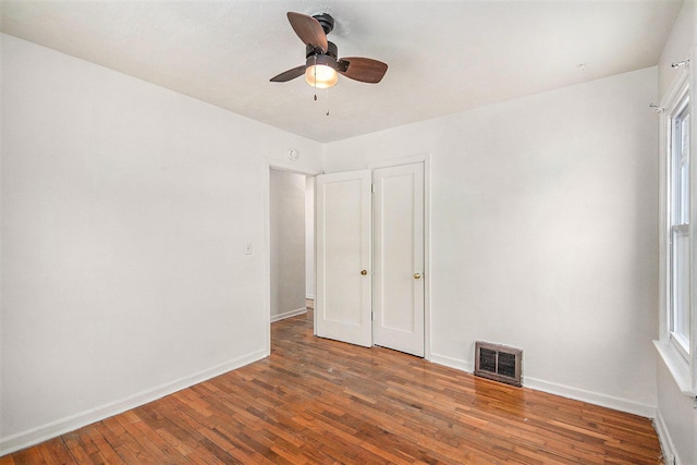 unfurnished bedroom with ceiling fan and dark hardwood / wood-style flooring