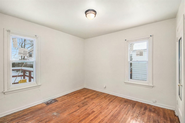 empty room featuring wood-type flooring and plenty of natural light