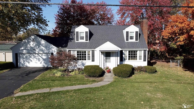 cape cod-style house featuring a garage and a front lawn