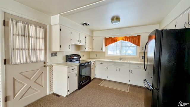 kitchen with sink, black appliances, and white cabinetry