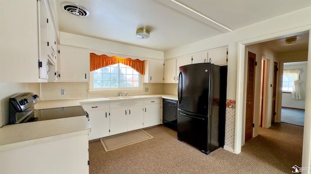 kitchen with sink, light colored carpet, black appliances, and white cabinetry