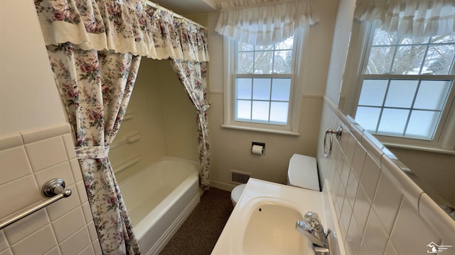 full bathroom featuring tile walls, shower / bathtub combination with curtain, toilet, and sink