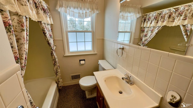 full bathroom with tile walls, toilet, separate shower and tub, and vanity