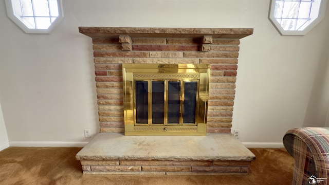 room details featuring a stone fireplace and carpet