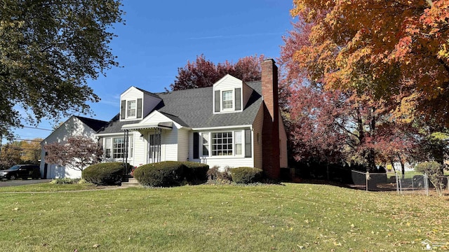 cape cod home featuring a front yard