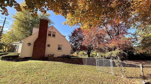 view of side of home featuring cooling unit and a lawn