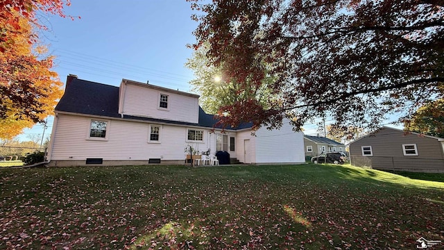 rear view of property featuring a lawn