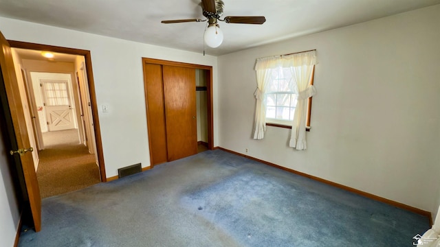 unfurnished bedroom with ceiling fan, a closet, and dark colored carpet