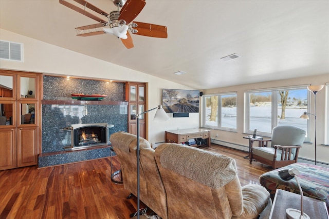 living room with vaulted ceiling, a baseboard radiator, a fireplace, ceiling fan, and wood-type flooring