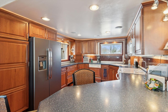 kitchen with sink, stainless steel fridge with ice dispenser, and stove