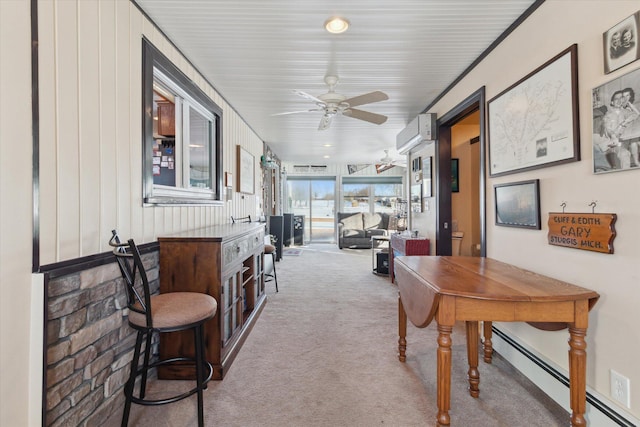 interior space with ceiling fan, a wall mounted air conditioner, ornamental molding, and a baseboard radiator