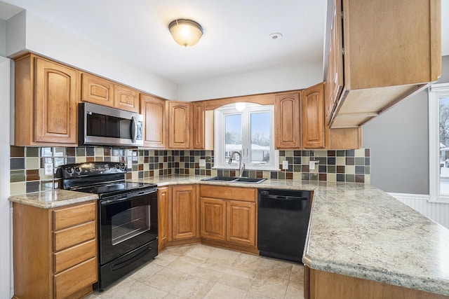 kitchen with sink, backsplash, black appliances, and light stone countertops