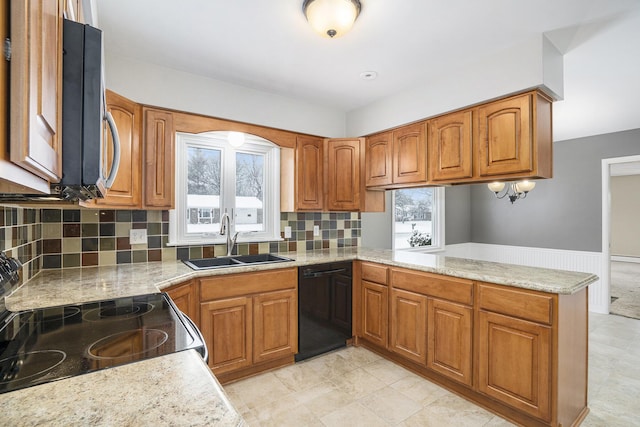 kitchen featuring dishwasher, kitchen peninsula, light stone counters, sink, and tasteful backsplash