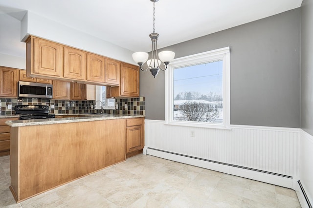 kitchen featuring pendant lighting, black range oven, a notable chandelier, decorative backsplash, and baseboard heating