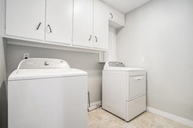 clothes washing area with washing machine and dryer and cabinets