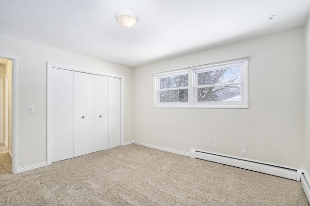 unfurnished bedroom featuring a baseboard radiator, a closet, and carpet