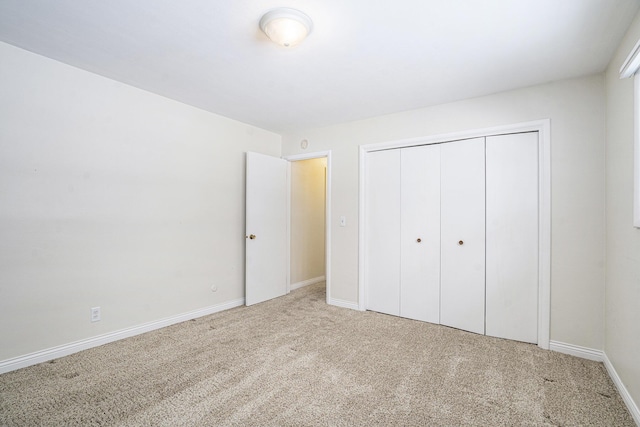 unfurnished bedroom with a closet and carpet flooring