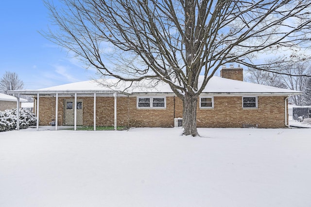 view of snow covered rear of property