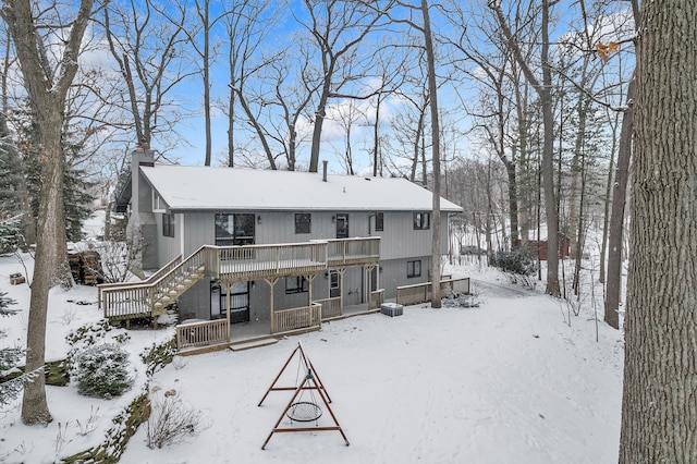 snow covered rear of property with a porch and central air condition unit