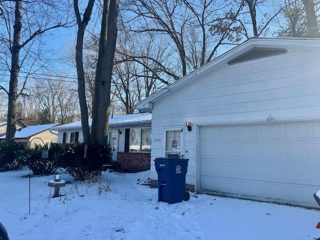 snow covered property with a garage