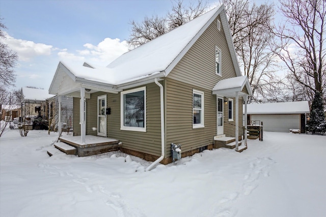 view of snowy exterior with a garage and an outdoor structure