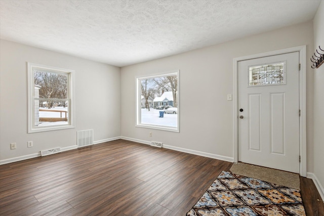 entrance foyer with a textured ceiling and dark hardwood / wood-style flooring