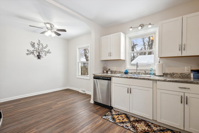 kitchen with dark wood-type flooring, stainless steel dishwasher, a wealth of natural light, white cabinets, and sink